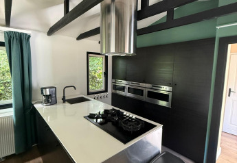 Moderne keuken in het «Private» Lodge bij Het Verscholen Dorp, Nederland, met zwarte balken en design.
