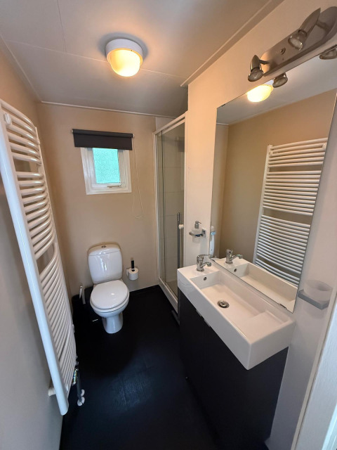 Moderne badkamer in Private Lodge bij Het Verscholen Dorp, Nederland, met douche, toilet en wastafel.