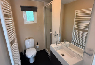 Moderne badkamer in Private Lodge bij Het Verscholen Dorp, Nederland, met douche, toilet en wastafel.