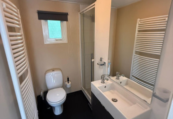 Moderne badkamer in Private Lodge bij Het Verscholen Dorp, Nederland, met douche, toilet en wastafel.