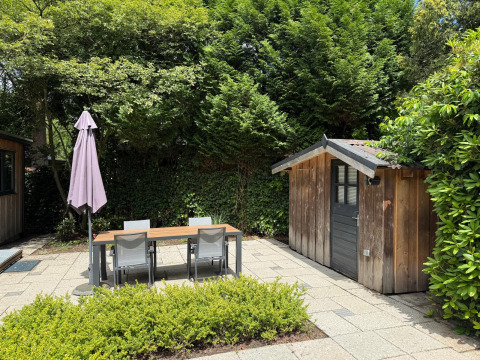 Gezellig terras met tuinmeubilair en houten tuinhuisje aan ‘Private’ Lodge, Het Verscholen Dorp.