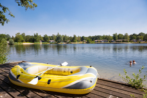 Vue sur le lac au parc de vacances Tolplas à Overijssel, Pays-Bas, avec un bateau gonflable et des nageurs.