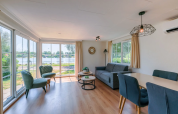 Helles Wohnzimmer im Chalet 4 am Tolplas in den Niederlanden mit Seeblick und moderner Einrichtung.
