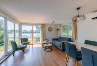 Helles Wohnzimmer im Chalet 4 am Tolplas in den Niederlanden mit Seeblick und moderner Einrichtung.