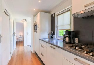 Cuisine moderne dans le Chalet 4 à Tolplas, Pays-Bas, avec cuisinière, cafetière et sol en bois clair.