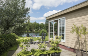 Chalet 4 au Tolplas aux Pays-Bas, terrasse avec table, chaises et vue sur le lac et la verdure.