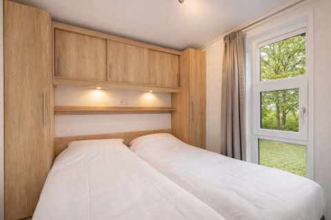 Chambre de la lodge Linde 4 Sauna à Tolplas, Pays-Bas, avec deux lits simples et des meubles en bois clair.