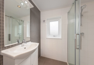 Modernes Badezimmer im Linde 4 Sauna bei Tolplas, Niederlande, mit Dusche und großem Spiegel.