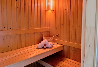 Binnenzicht van de sauna in Linde 4 Sauna te Tolplas, Nederland, met handdoek, emmer en fles.
