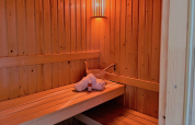Intérieur d’un sauna au Linde 4 Sauna à Tolplas, Pays-Bas, avec serviette, seau et bouteille.