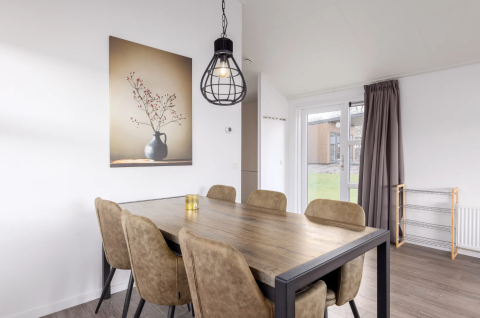 Salle à manger du lodge Schipbeek 6 à Tolplas, Pays-Bas, avec table moderne, six chaises et décoration sobre.