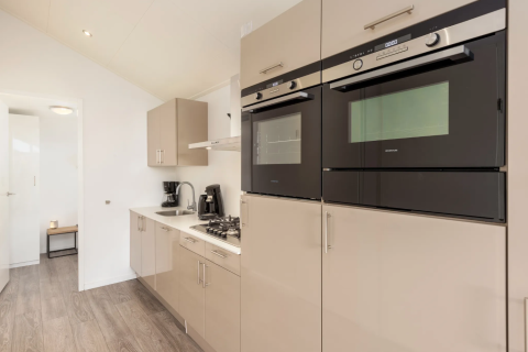Cuisine moderne à Schipbeek 6, Tolplas, Pays-Bas avec fours encastrés et cuisinière à gaz dans la lodge.