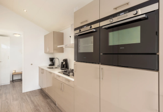 Modern kitchen appliances in a lodge at Schipbeek 6, Tolplas, Netherlands with built-in ovens and stove.