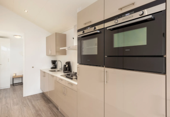 Moderne Küche in einer Lodge auf Schipbeek 6, Tolplas, Niederlande mit Einbauöfen und Gasherd.