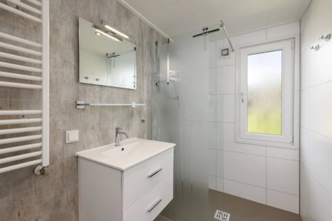 Moderne badkamer in Schipbeek 6, Tolplas, Nederland, met een douche, wastafel, spiegel en raam.