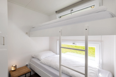 Heldere, moderne kamer met stapelbed en groot raam in Schipbeek 6 lodge aan Tolplas, Nederland.