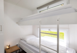 Chambre moderne et lumineuse avec lits superposés et grande fenêtre à la lodge Schipbeek 6 à Tolplas.
