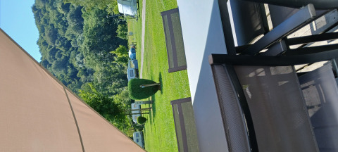 Uitzicht vanuit de Coco Sweet safaritent op Camping Floreal La Roche-en-Ardenne met stoelen en groen gras.