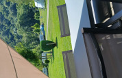 Vista dalla tenda safari Coco Sweet al Camping Floreal La Roche-en-Ardenne con sedie e prato verde.