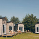 Four cozy Koya Tiny Loft houses at Wilsumer Berge in Germany with wooden decks and nature surroundings.