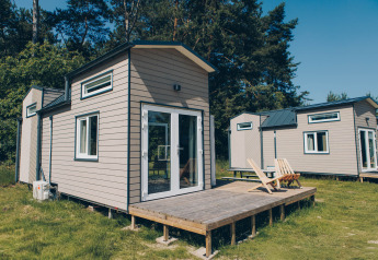 Afbeelding van de 'Koya Tiny Loft' tiny houses bij Wilsumer Berge in Duitsland, met terras en natuur eromheen.