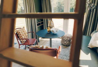 Coin salon contemporain du Koya Tiny Loft à Wilsumer Berge, Allemagne, vu à travers une échelle en bois.