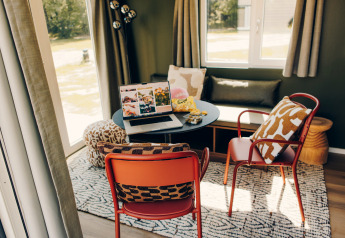 Espace de travail douillet au Koya Tiny Loft, Wilsumer Berge, Allemagne, avec ordinateur portable et chaises.