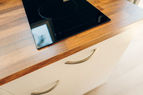 A modern induction cooktop installed in a wooden countertop at Koya Tiny Loft, Wilsumer Berge, Germany.