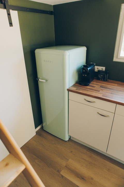 Small kitchen corner with a retro fridge and coffee maker in Koya Tiny Loft at Wilsumer Berge, Germany.