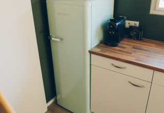 Small kitchen corner with a retro fridge and coffee maker in Koya Tiny Loft at Wilsumer Berge, Germany.