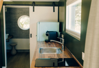 Modern kitchen inside the tiny house 'Koya Tiny Loft' at Wilsumer Berge, Germany, with wood countertop.