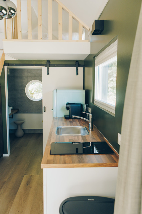 Modern kitchen inside the tiny house 'Koya Tiny Loft' at Wilsumer Berge, Germany, with wood countertop.