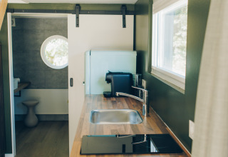 Modern kitchen inside the tiny house 'Koya Tiny Loft' at Wilsumer Berge, Germany, with wood countertop.