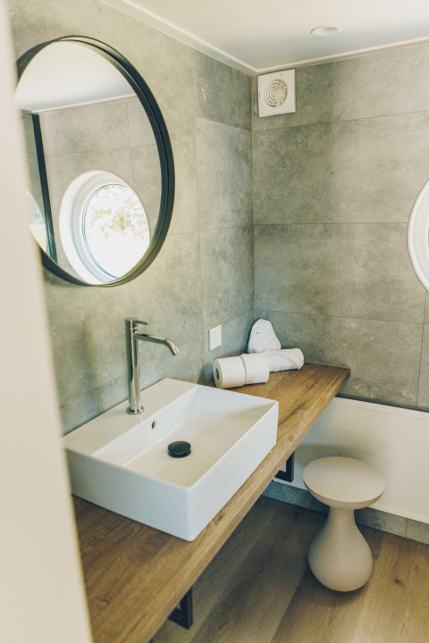Modern bathroom at Koya Tiny Loft, Wilsumer Berge, Germany, featuring a sink, mirror, and wood counter.