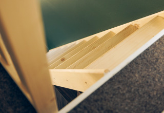 Wooden stairs viewed from above in a compact space at Koya Tiny Loft, Wilsumer Berge, Germany.