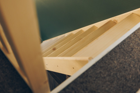 Wooden stairs viewed from above in a compact space at Koya Tiny Loft, Wilsumer Berge, Germany.