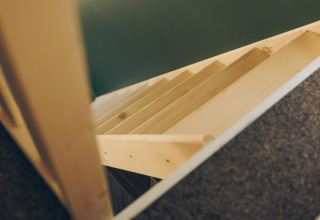 Wooden stairs viewed from above in a compact space at Koya Tiny Loft, Wilsumer Berge, Germany.