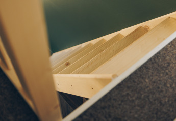 Wooden stairs viewed from above in a compact space at Koya Tiny Loft, Wilsumer Berge, Germany.