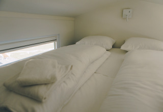 Cozy sleeping area with two beds and white linens in Koya Tiny Loft, Wilsumer Berge, Germany.