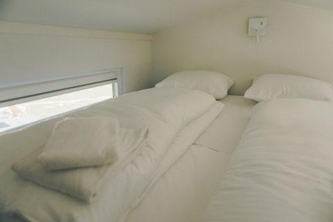 Cozy sleeping area with two beds and white linens in Koya Tiny Loft, Wilsumer Berge, Germany.