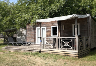 Mobile Home Premium bij Flower Camping Les Ondines in Frankrijk met houten terras en groene graspartij ervoor.