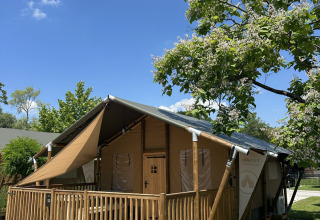 Tenda safari 'Outback' al Camping Terme Tuhelj in Croazia, immersa nel verde e sotto un cielo limpido.