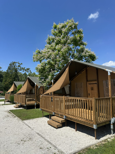 Tenda safari 'Outback' al Camping Terme Tuhelj in Croazia con veranda in legno e cielo azzurro.