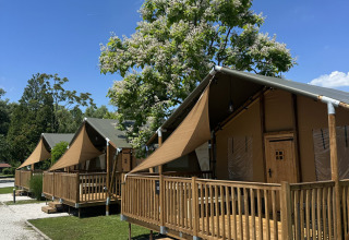 Tenda safari 'Outback' al Camping Terme Tuhelj in Croazia con veranda in legno e cielo azzurro.