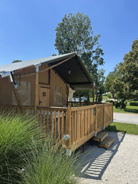 Tenda safari Outback al Camping Terme Tuhelj in Croazia con veranda in legno e area verde.