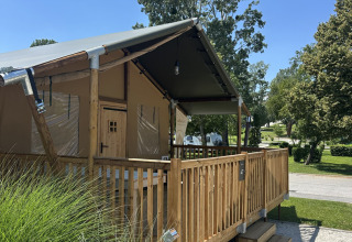 Tenda safari Outback al Camping Terme Tuhelj in Croazia con veranda in legno e area verde.