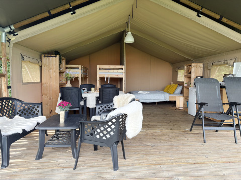 Binnenzijde van een ruime safaritent bij Camping de Regenboog in Tsjechië, met bedden en zithoek.