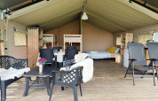 Interior of a spacious safari tent at Camping de Regenboog in Czech Republic, showing bed and seating area.