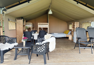 Interior of a spacious safari tent at Camping de Regenboog in Czech Republic, showing bed and seating area.