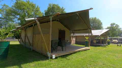 Safari-Zelt auf dem Campingplatz De Rammelbeek in den Niederlanden, mit Terrasse und Gartenmöbeln.